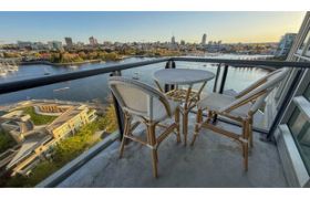 Furnished balcony with a stunning city view and waterfront access.