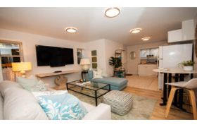 Furnished 2-bedroom suite with black railings and steps leading up to the entrance.