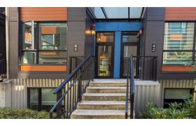 Modern 3-bedroom townhouse with sleek black railings and large windows, offering a cozy and stylish living space.