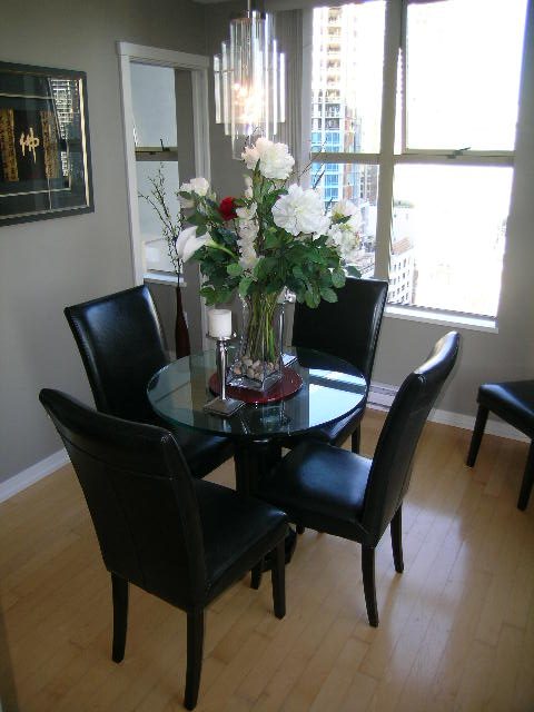 Dining area with black leather chairs, glass table, city view, hardwood floors. - 703 - 1000 Beach Avenue, Vancouver Downtown