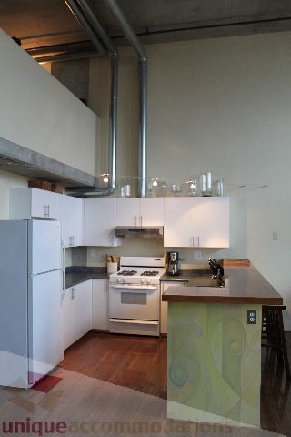 Bright kitchen with white cabinets, stainless steel appliances, and hardwood floors. - 627 - 289 Alexander Street, Vancouver Downtown