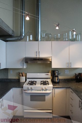 Bright kitchen with white cabinets, stainless steel appliances, and modern lighting. - 627 - 289 Alexander Street, Vancouver Downtown
