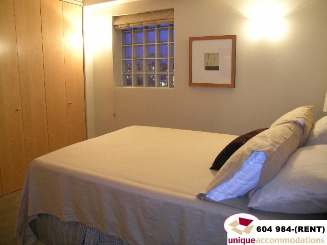 Furnished bedroom with neatly made bed and framed artwork above. - 700 - 1888 York Ave, Vancouver West Side