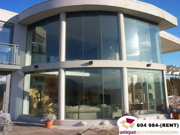 Furnished living room with large glass windows and modern furniture. - 700 - 1888 York Ave, Vancouver West Side