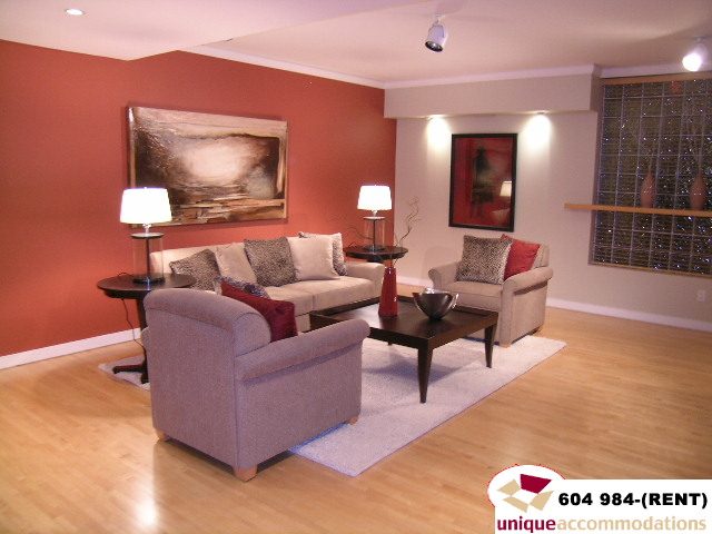 Furnished living room with hardwood floors, modern decor, and a large abstract painting on the wall. - 700 - 1888 York Ave, Vancouver West Side