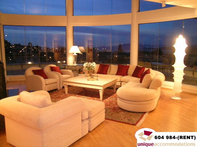 Furnished living room with large windows, hardwood floors, and a city view. - 700 - 1888 York Ave, Vancouver West Side