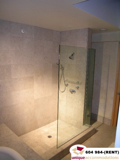 Furnished bathroom with glass shower and beige tile walls. - 700 - 1888 York Ave, Vancouver West Side