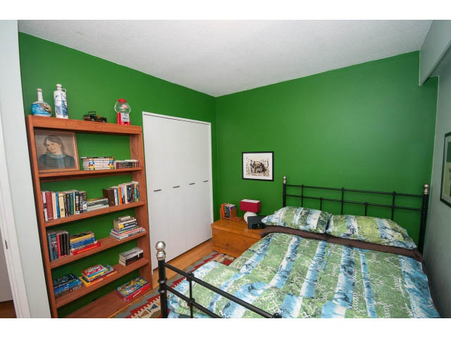 Bright bedroom with green walls, wooden bookshelf, and patterned bedding. - 1007 Shavington (Upper), North Vancouver