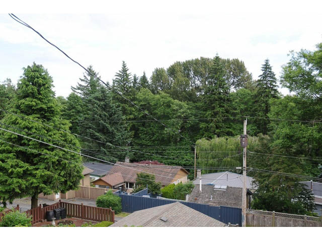 Furnished living room with city view and lush greenery. - 1007 Shavington (Upper), North Vancouver