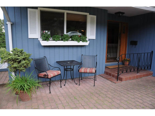 Furnished patio with blue siding, brick flooring, and outdoor seating. - 1007 Shavington (Upper), North Vancouver