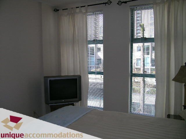 Furnished bedroom with city view and large windows. - 509 - 939  Homer Street, Vancouver Downtown