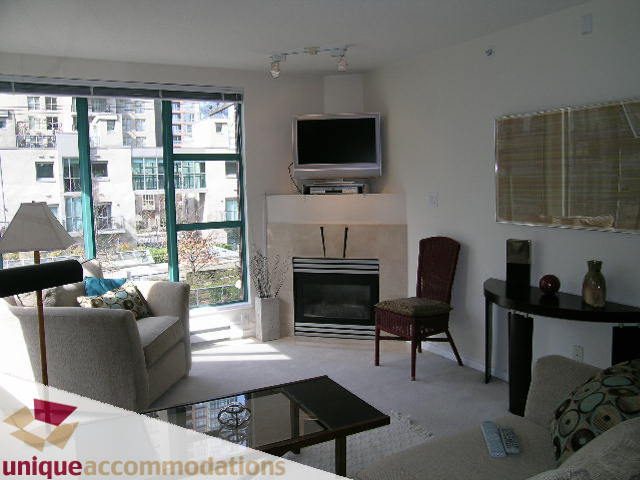 Spacious living room with large windows, city view, and modern furniture. - 509 - 939  Homer Street, Vancouver Downtown