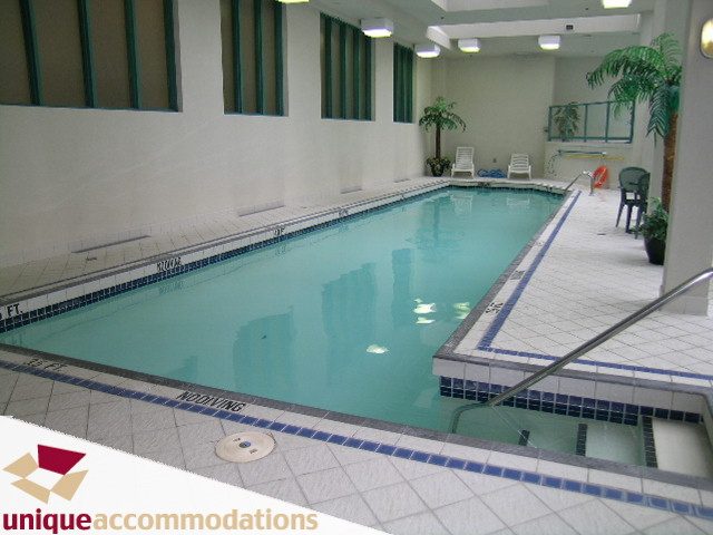 Spacious, well-lit indoor pool area with tiled floor and lounge chairs. - 509 - 939  Homer Street, Vancouver Downtown