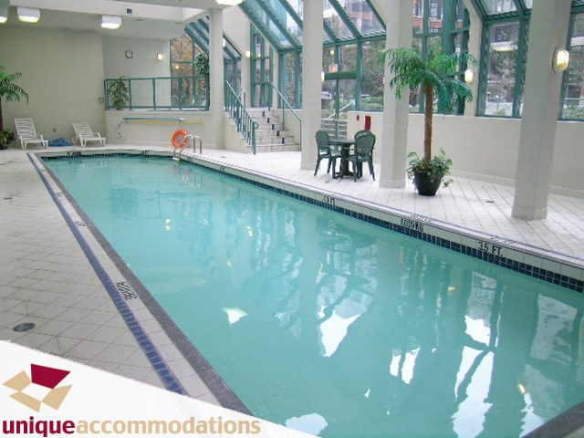 Spacious indoor pool area with glass walls, modern decor, and a serene ambiance. - 509 - 939  Homer Street, Vancouver Downtown