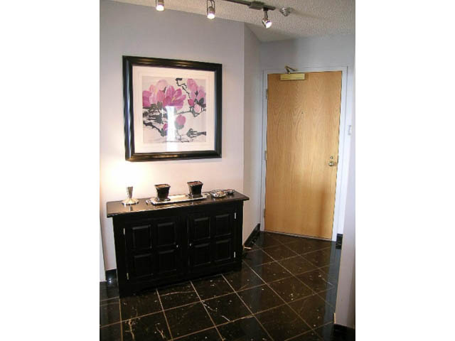 Bright entryway with black cabinets, marble countertop, and framed artwork. - 1402 - 1625 Hornby, Vancouver Downtown