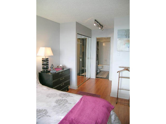 Furnished bedroom with hardwood floors and a cozy bed setup. - 1402 - 1625 Hornby, Vancouver Downtown