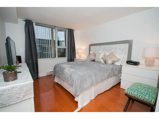 Furnished 2-bedroom condo with hardwood floors, white countertops, and a cozy bed setup. - 407 - 1485 West 6th Ave, Vancouver West Side
