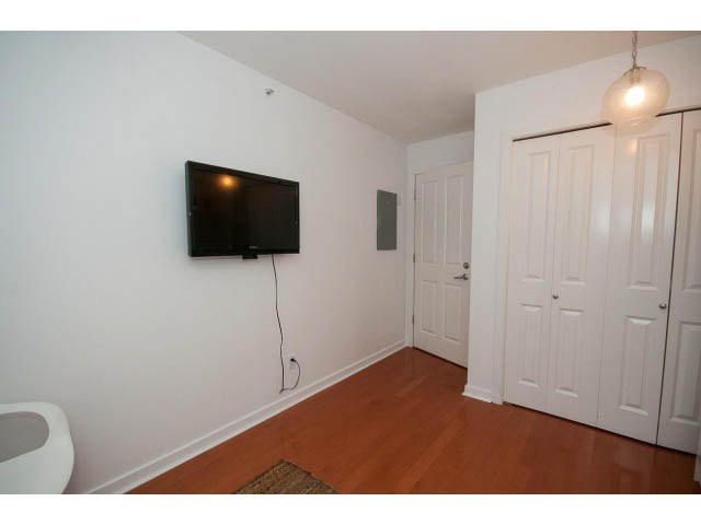 Bright living room with hardwood floors and a mounted TV. - 407 - 1485 West 6th Ave, Vancouver West Side