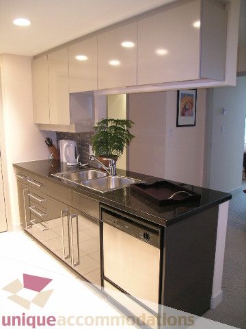 Bright kitchen with modern white cabinets, stainless steel appliances, and a sleek countertop. - 3101 - 1408 Strathmore Mews, Vancouver Downtown