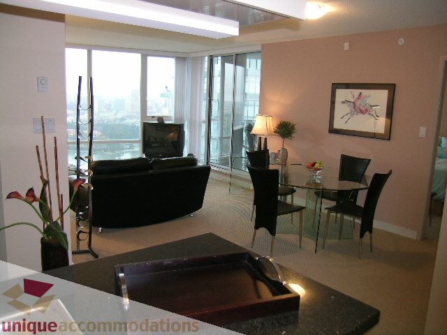 Furnished living room with granite countertops, city view, and modern decor. - 3101 - 1408 Strathmore Mews, Vancouver Downtown