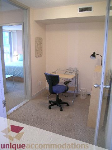 Bright den with desk, chair, and lamp; carpeted floor; city view. - 3101 - 1408 Strathmore Mews, Vancouver Downtown