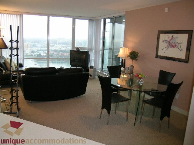Furnished dining area with modern chairs and city view through large windows. - 3101 - 1408 Strathmore Mews, Vancouver Downtown