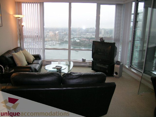 Furnished living room with a city view and modern furniture. - 3101 - 1408 Strathmore Mews, Vancouver Downtown