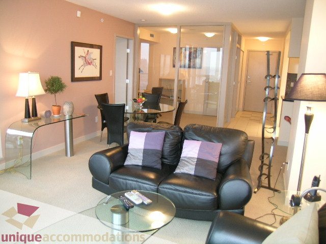 Furnished living room with black leather furniture, glass coffee table, and modern decor. - 3101 - 1408 Strathmore Mews, Vancouver Downtown