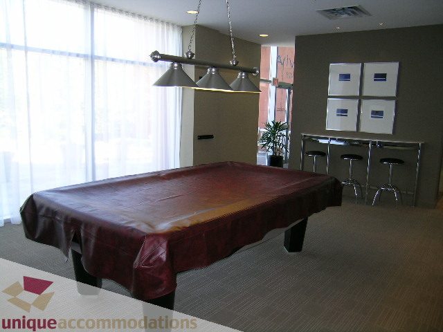 Furnished living room with leather couch and modern lighting. - 3101 - 1408 Strathmore Mews, Vancouver Downtown