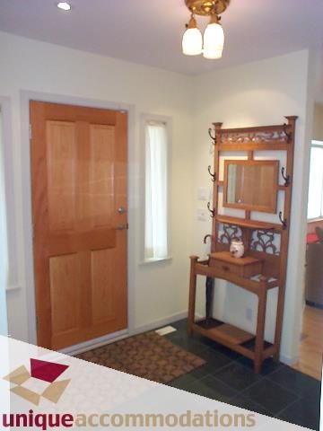 Foyer with wooden door, coat rack, and small table. - 2750 Waterloo Street, Vancouver West Side