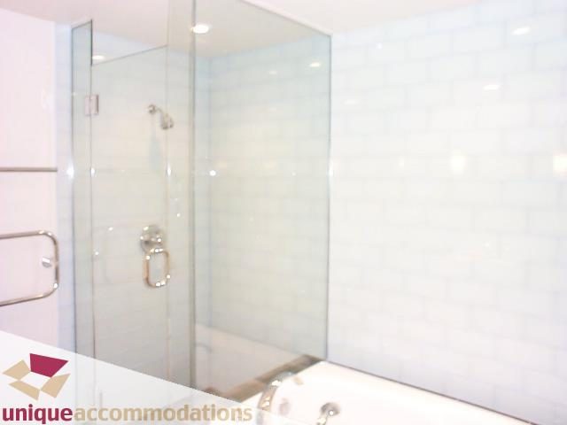 Bright bathroom with white subway tiles and a glass shower enclosure. - 2104 - 1233 West Cordova Street, Vancouver Downtown