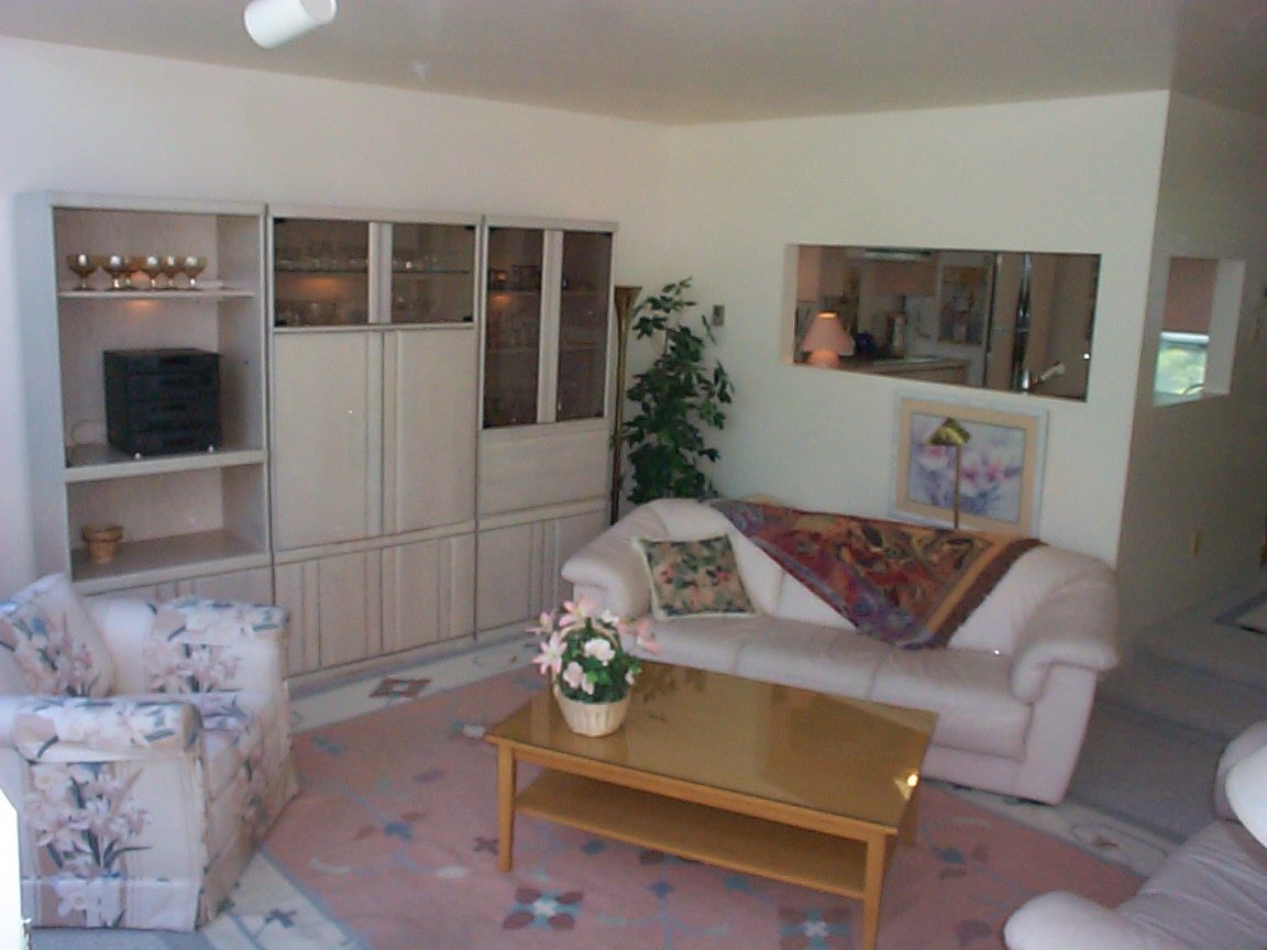 Bright living room with white furniture, glass coffee table, and large window view. - 832 West 7th Avenue, Vancouver West Side