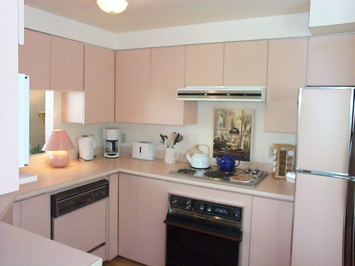 Bright kitchen with light pink cabinets, white countertops, and a small artwork above the stove. - 832 West 7th Avenue, Vancouver West Side
