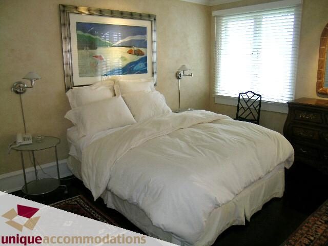 Spacious bedroom with two twin beds, white linens, and a large window with blinds. - 2427 Point Grey Road, Vancouver West Side
