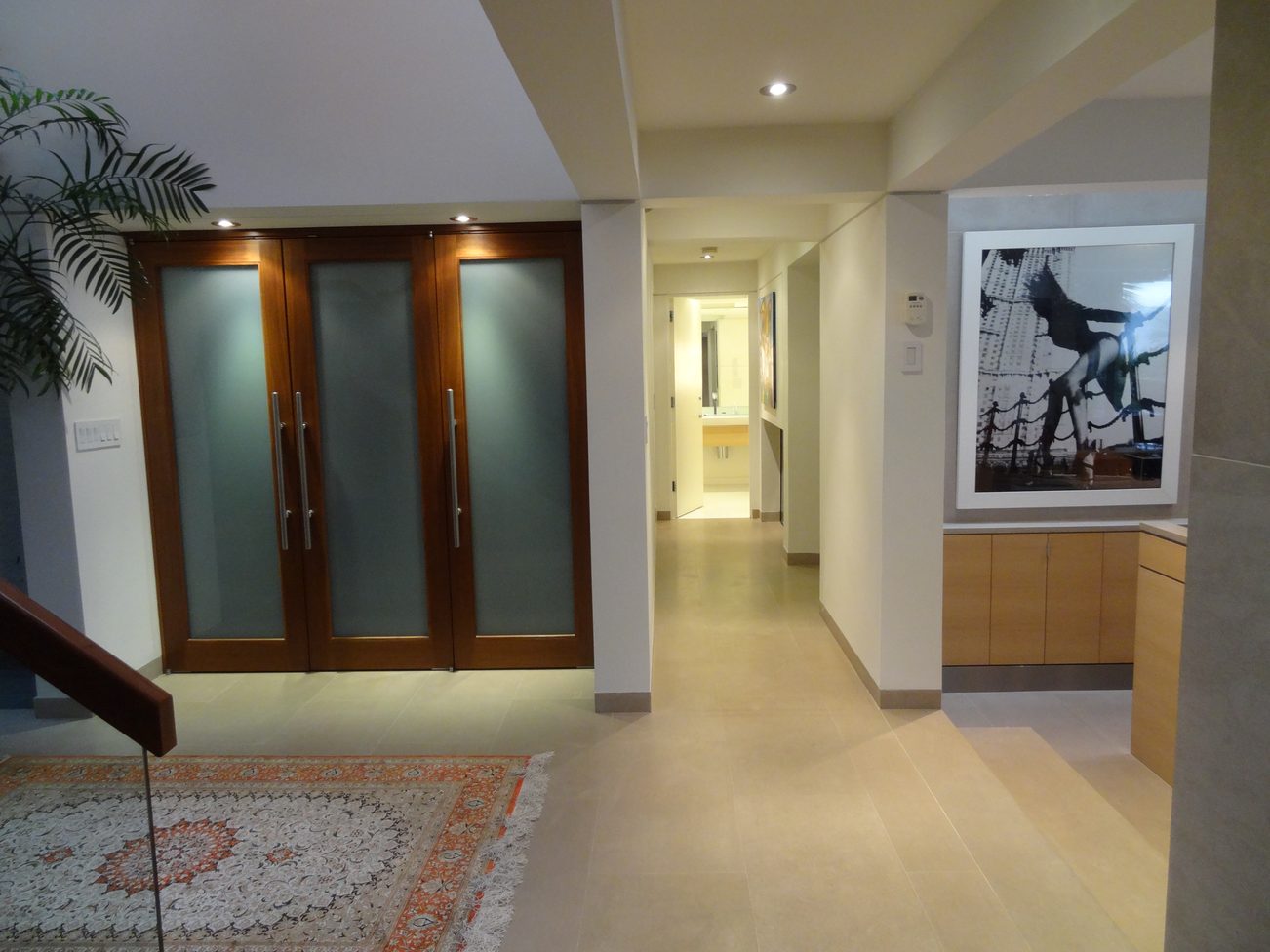 Foyer with frosted glass doors, modern artwork, and tiled flooring. - 2898 Bellevue Avenue, West Vancouver