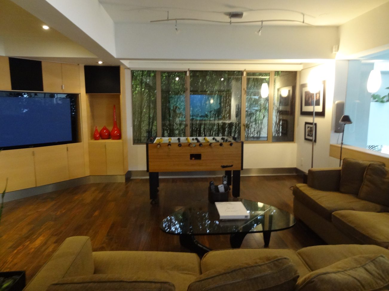 Furnished living room with hardwood floors, large windows, and a foosball table. - 2898 Bellevue Avenue, West Vancouver