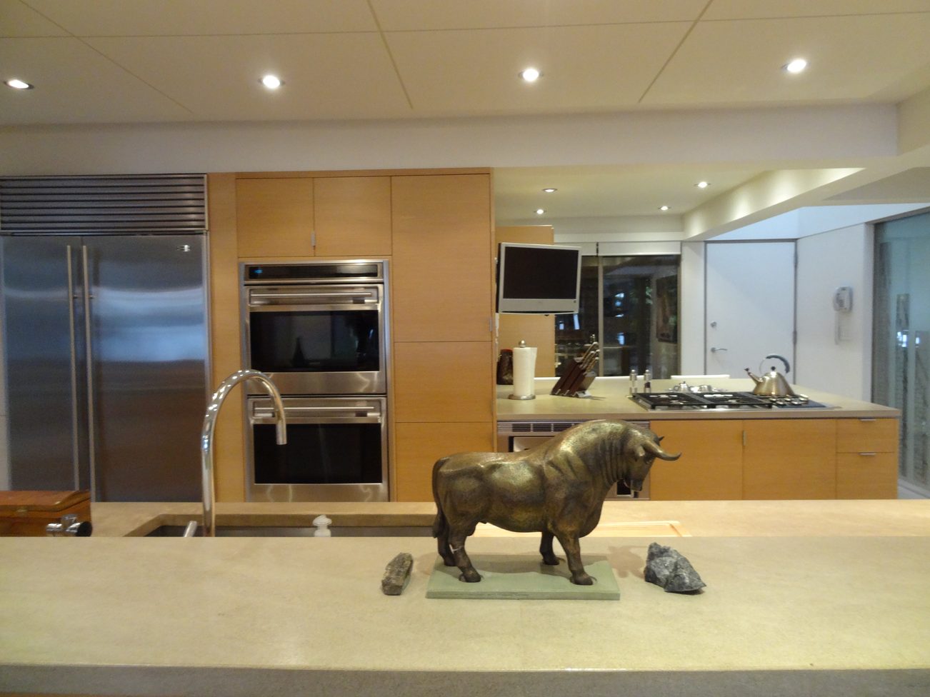 Bright kitchen with modern appliances, granite countertops, and a unique bull sculpture centerpiece. - 2898 Bellevue Avenue, West Vancouver