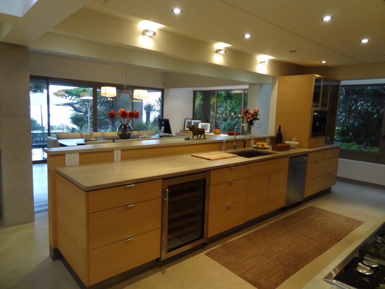 Bright kitchen with wooden cabinets, large windows, and a view of greenery outside. - 2898 Bellevue Avenue, West Vancouver