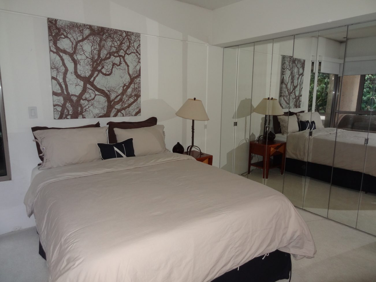 Spacious bedroom with mirrored closet, neutral decor, and tree art. - 2898 Bellevue Avenue, West Vancouver