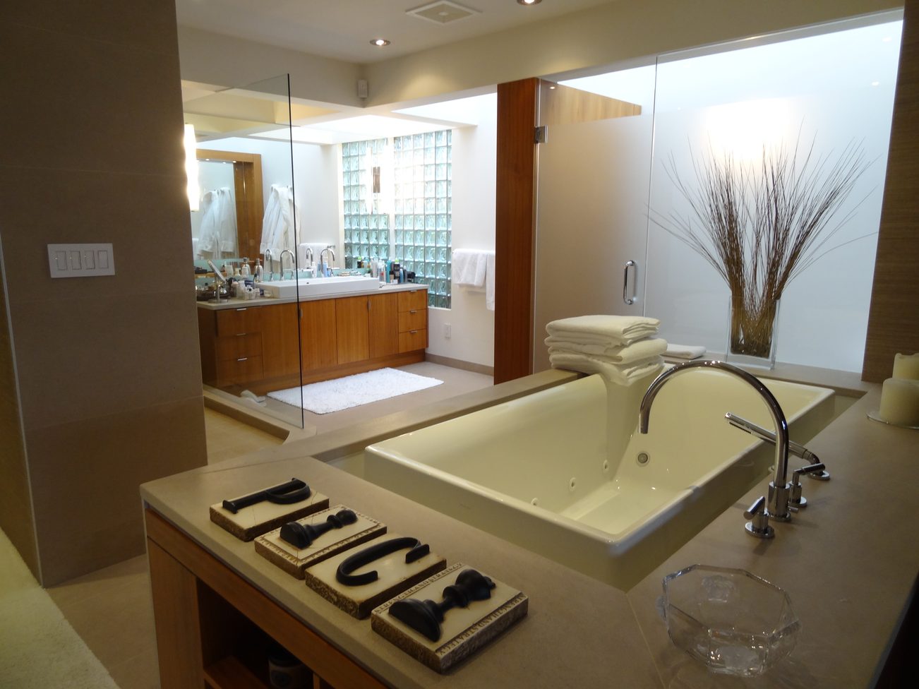 Furnished bathroom with dual sinks, large bathtub, and frosted glass shower door. - 2898 Bellevue Avenue, West Vancouver