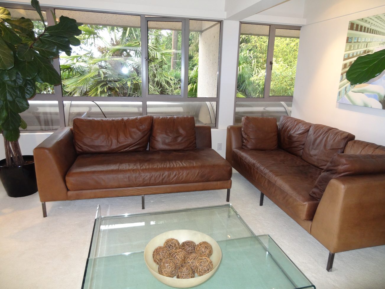 Bright living room with large windows, leather furniture, and a glass coffee table. - 2898 Bellevue Avenue, West Vancouver