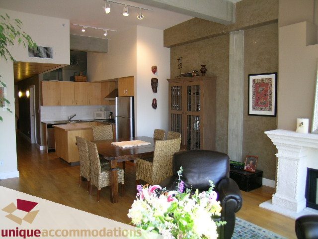 Furnished living room with hardwood floors, modern decor, and a cozy fireplace. - PH3  603 - 1155 Mainland, Vancouver Downtown