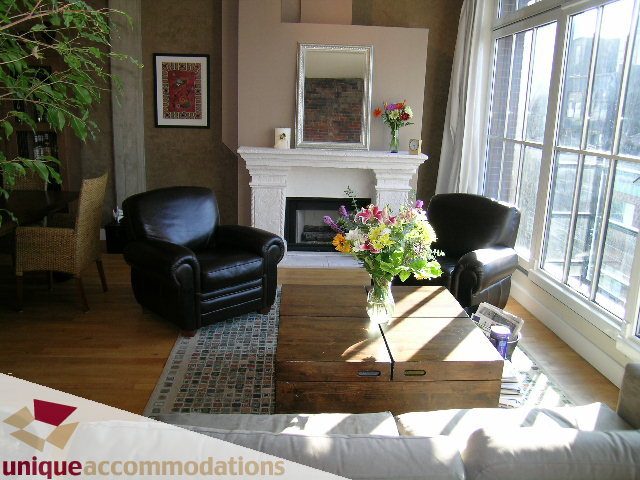 Bright living room with hardwood floors, large windows, and a cozy fireplace. - PH3  603 - 1155 Mainland, Vancouver Downtown