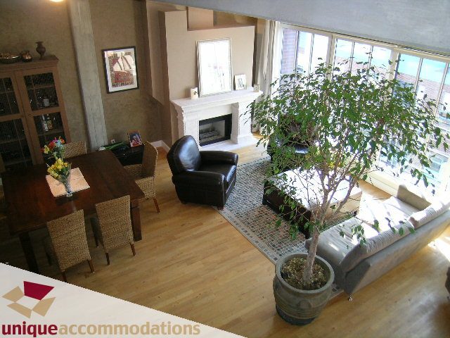 Furnished living room with hardwood floors, large windows, and a cozy fireplace. - PH3  603 - 1155 Mainland, Vancouver Downtown