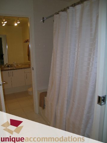 Bright bathroom with white shower curtain and beige countertop. - PH3  603 - 1155 Mainland, Vancouver Downtown