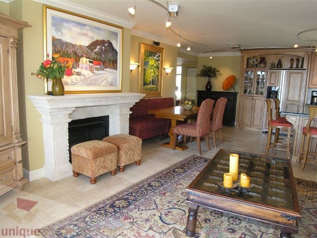 Living room with a large fireplace, patterned rug, and dining area in the background. - 706 - 1600 Howe Street, Vancouver Downtown