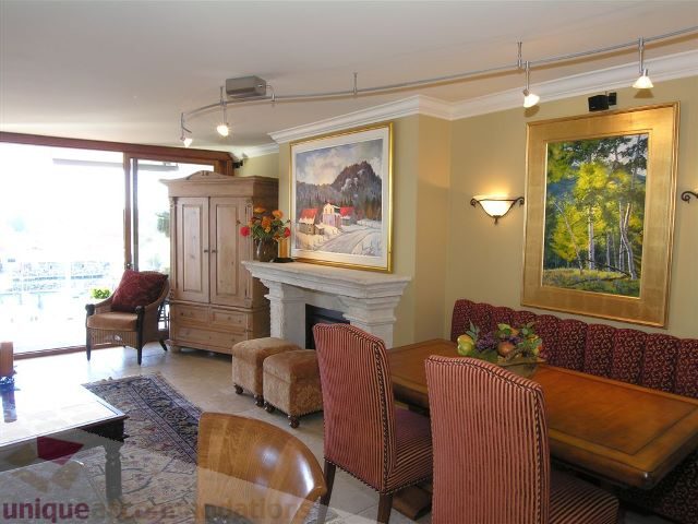 Furnished living room with striped chairs, wooden coffee table, and large paintings. - 706 - 1600 Howe Street, Vancouver Downtown