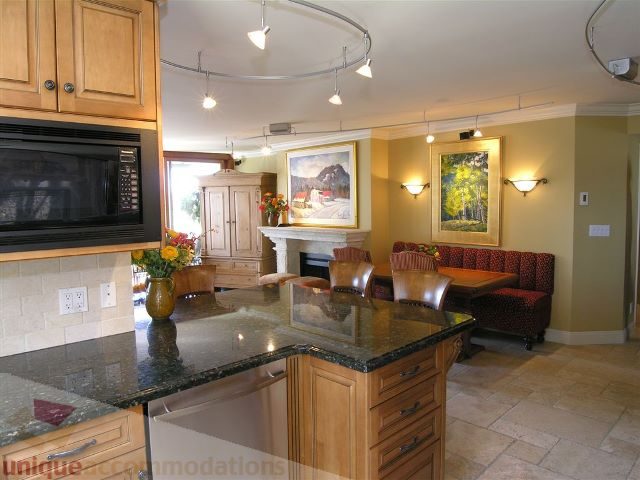 Bright kitchen with granite countertops, wooden cabinets, and a cozy dining nook. - 706 - 1600 Howe Street, Vancouver Downtown