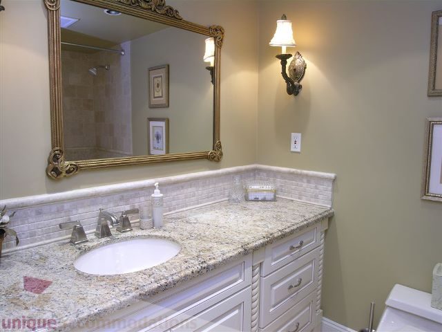 Bathroom with granite countertop, white cabinetry, and ornate mirror. - 706 - 1600 Howe Street, Vancouver Downtown