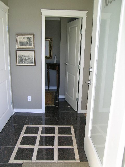 Spacious hallway leading to a den with dark tile flooring and framed artwork. - 1035 Marinaside Crescent, Vancouver Downtown